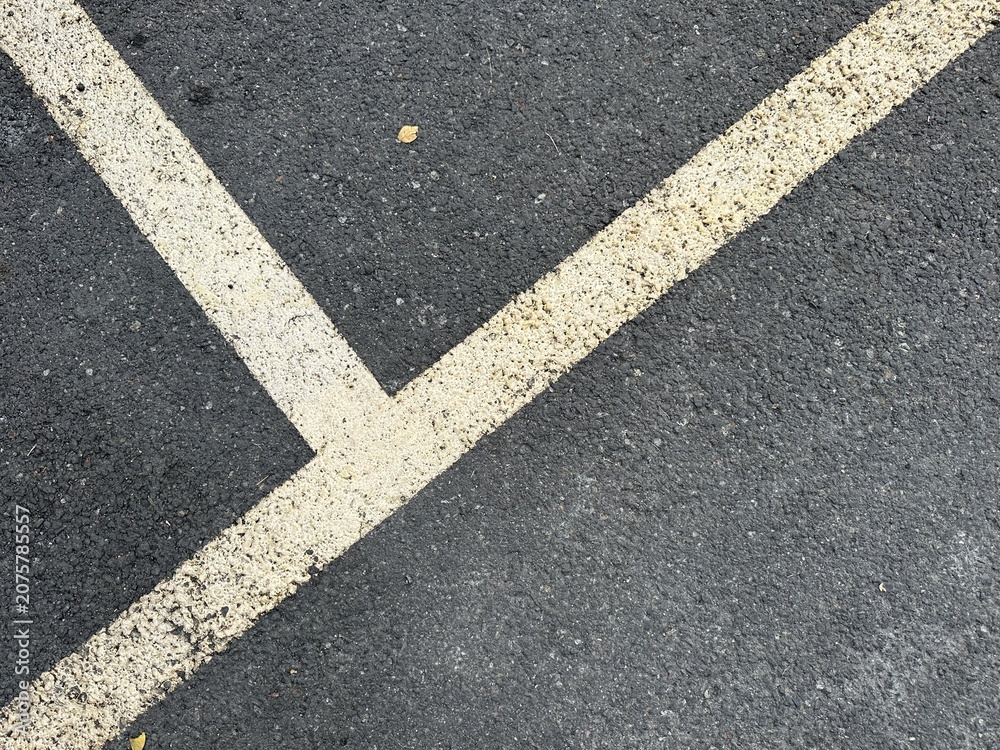 Fototapeta premium Diagonal Parking Lot Lines on Asphalt Surface