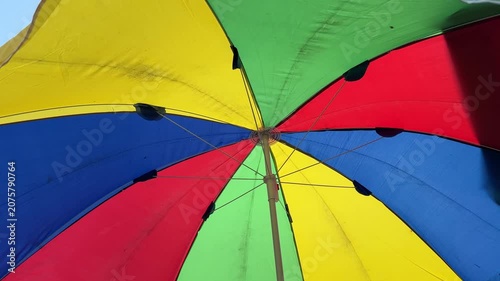 Opening a Colorful Umbrella Canopy in Bright Outdoor Setting
