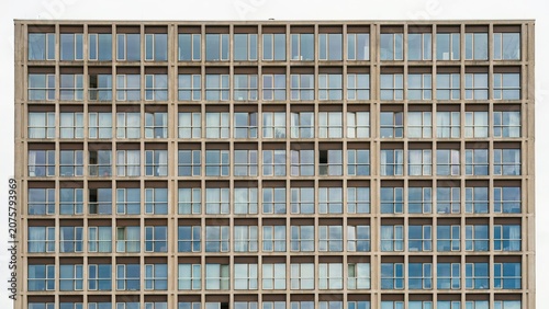 Skyscraper facade displays a repeating grid pattern of modern windows across the entire exterior wall structure.