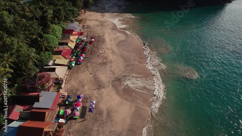 Aerial View of Sandy Beach with Traditional Outrigger Boats, People and Gentle Ocean Waves