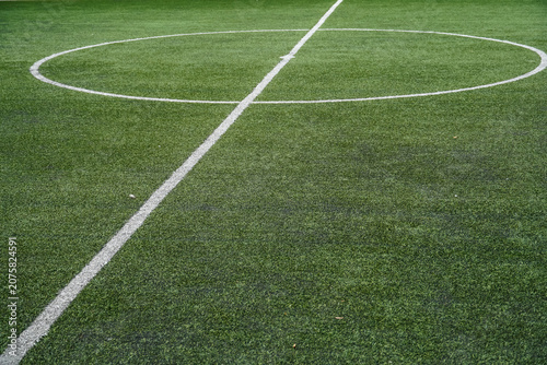 Close-up view of a green artificial turf soccer field with white markings