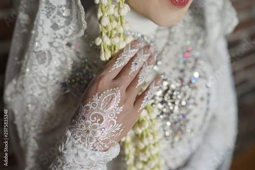Detailed close-up of a bride in white lace and white henna art for a traditional wedding ceremony