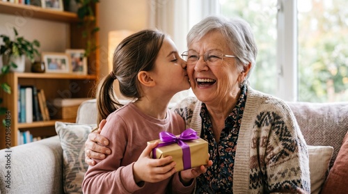 Little girl gives a surprise gift and a kiss to her happy grandmother