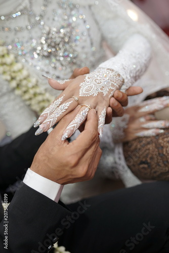 Close up of Newlywed Couple Holding Hands with Intricate White Lace and Bridal Henna
