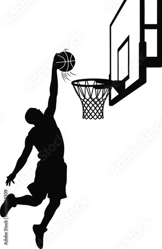 Silhouette basketball player dunking ball during game against hoop with bright studio lighting