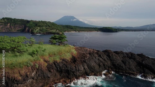 Aerial View of Rocky Island, Ocean Coastline, Sailboats and Distant Volcanoes in Bali