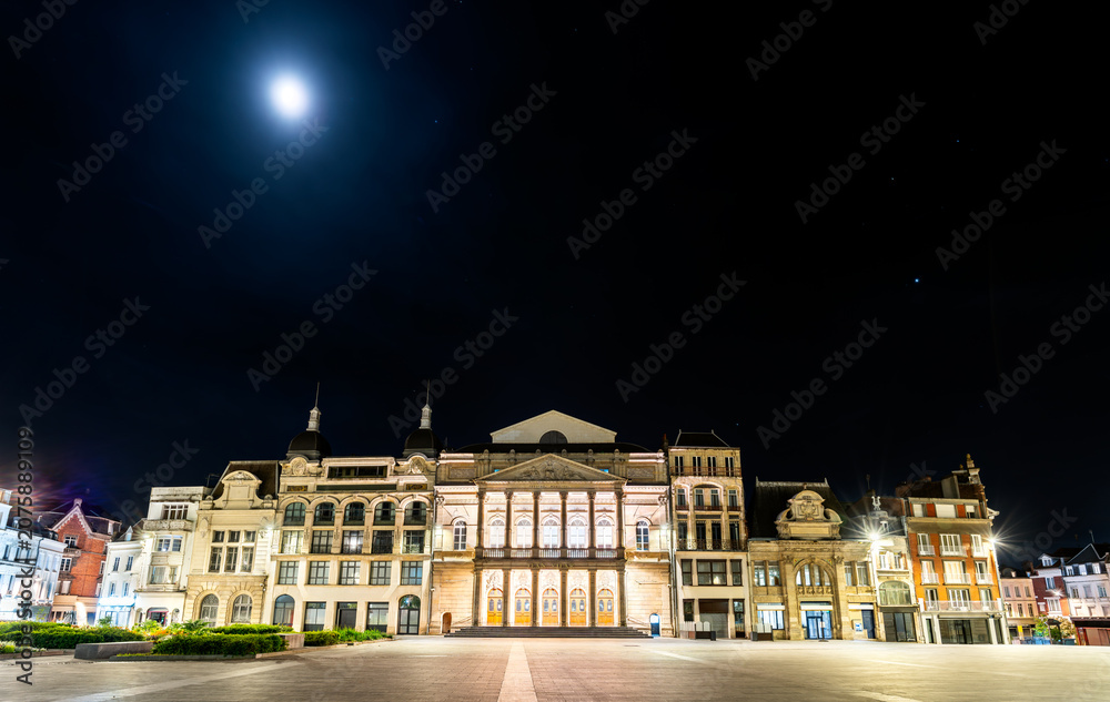 Obraz premium The illuminated facade of Theater Jean Vilar on a clear night under a full moon in the historic center of Saint-Quentin, France.
