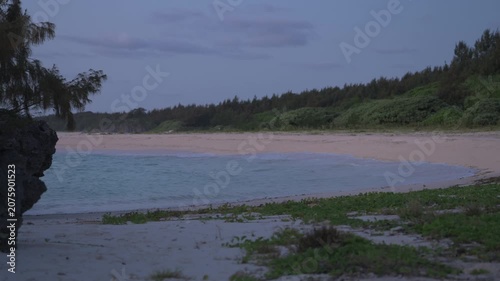 朝日に照らされる美しい波打ち際とシルエットの島影（スローモーション）