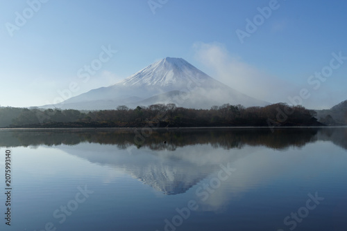 Serene landscape of Mount Fuji and its perfect reflection on the misty water of Lake Shoji in April, Yamanashi, Japan.