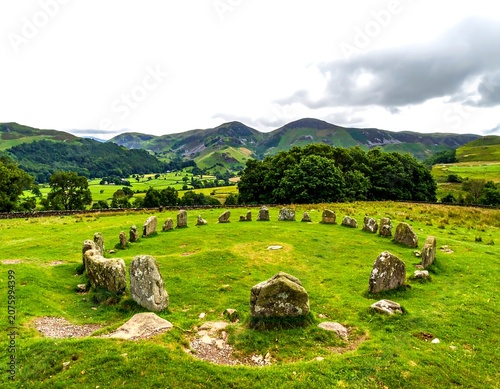 Serene landscape with sheep grazing in rolling hills.
