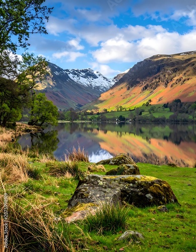 A serene lake surrounded by mountains and trees under a blue sky