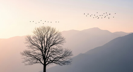 Minimalist landscape photography featuring silhouette tree with migrating bird flock flying above hazy mountain peaks during serene morning golden.
