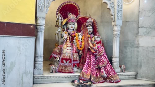 Sacred statue of Lord Shiva with his divine bull Nandi, adorned with vibrant flower garlands inside a Hindu temple. The devotional image reflects faith, strength, protection