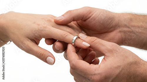 Man putting a silver wedding ring on a woman's finger during a romantic engagement ceremony
