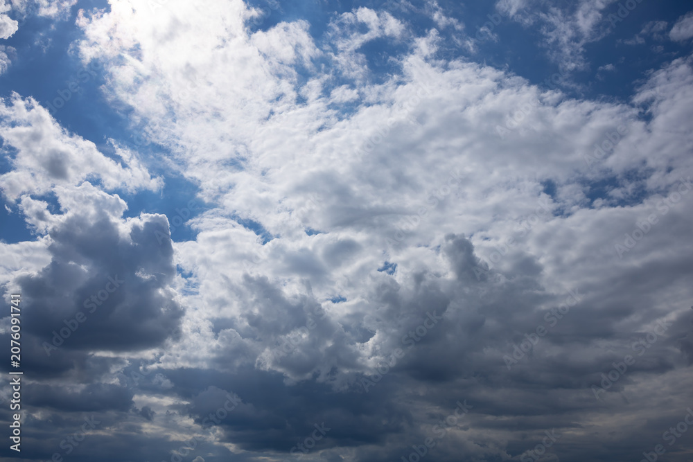 Obraz premium Large White Clouds Drifting Across a Bright Blue Sky. Expansive white clouds floating across a vivid blue sky, creating a peaceful natural background suitable for weather, travel, and summer themes.