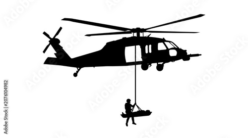 Helicopter rescue team member lowers a stretcher to transport an injured person from a remote location to medical care.
