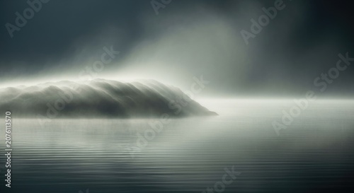 Misty Mountain Landscape with Calm Water and Atmospheric Haze.