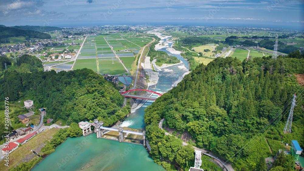 Fototapeta premium 梅雨の晴れ間の愛本橋と広がる黒部川扇状地とさらに奥に見える日本海