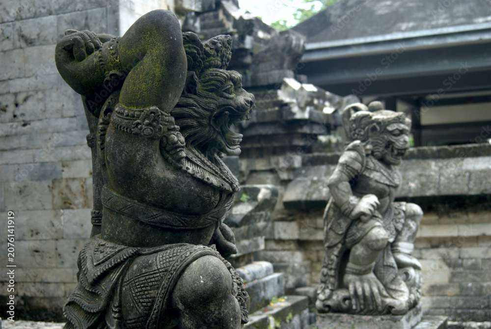 Fototapeta premium Two Weathered Guardian Statues Before Temple