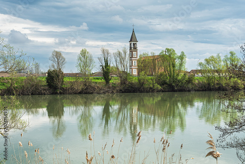 view of the church bell tower reflected in the waters of the Adige river, San Pietro di Cavarzere, Venice