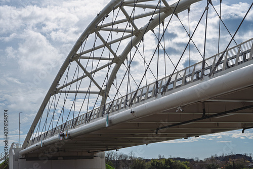 a modern metal bridge inside the Polesine campaigns with a cloudy sky in the background, Rovigo, Italy 