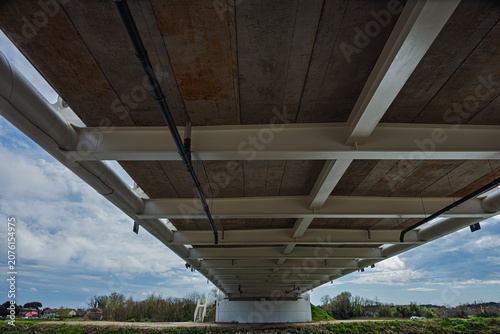 a modern metal bridge inside the Polesine campaigns with a cloudy sky in the background, Rovigo, Italy 