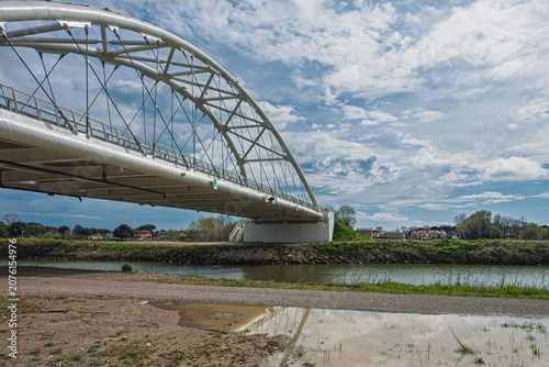 a modern metal bridge inside the Polesine campaigns with a cloudy sky in the background, Rovigo, Italy 