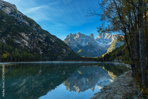 Morning reflection of the Dolomite Mountains in calm alpine lake, Italy
