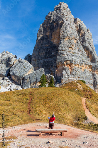 Hiker enjoying breathtaking view of Dolomite mountains in Cinque Torri, Italy