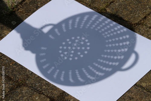 фотографія Demonstration of the use of a colander to project an image of a solar eclipse to