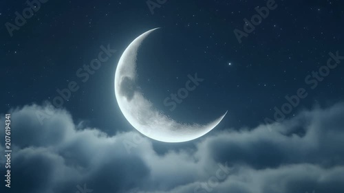 A beautiful crescent moon shining brightly in the dark night sky above soft clouds.