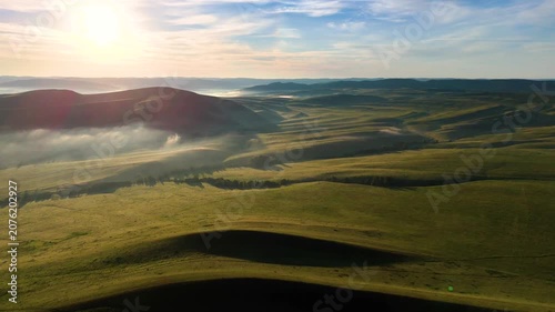 Landscape with green mountains, mist at dawn, and clouds