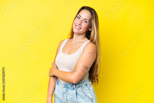 Young caucasian woman isolated on yellow background laughing