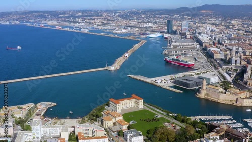 Aerial drone view of the Marseille port entrance with Corsica Linea ferry, MuCEM, Fort Saint-Jean, and Palais du Pharo gardens in Marseille, France, daytime.