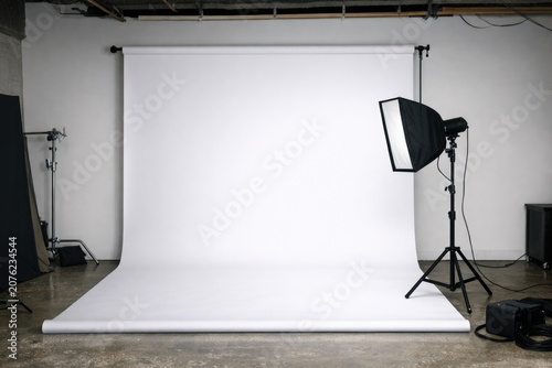 Professional photography studio setup with white backdrop and lighting gear for capturing images