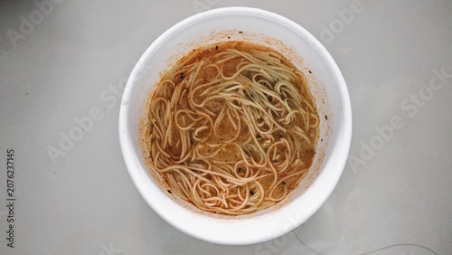 Foto Top View of Instant Vermicelli Noodle Soup in White Paper Cup on Gray Background