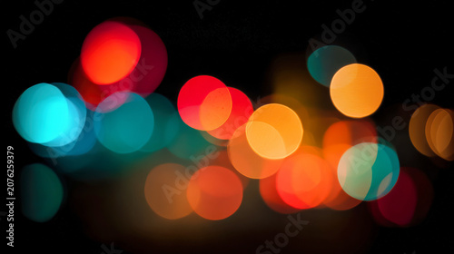Colorful bokeh lights create a festive atmosphere in the dark setting with soft glowing circles