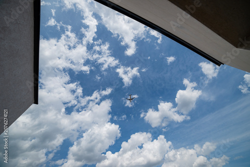 A plain over blue sky with white fluffy clouds