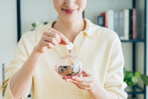 Bild auf Leinwand 貯金する若い女性の手元