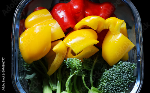 Red and yellow fresh peppers in a bowl