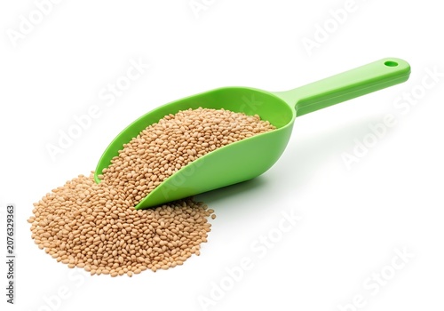 Green plastic scoop full of dry brown lentils pouring onto a pile