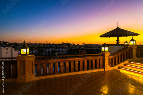 A magical sunrise over the sea with Egyptian resort hotels lining coast. A vibrant, romantic resort landscape.