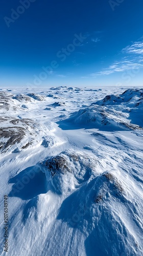 Scandinavia isolated snowfield minimalism Vast arctic tundra landscape covered in deep snow with rocky outcrops under clear bright blue winter sky