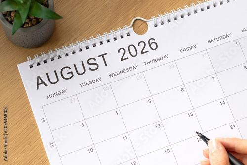 August 2026 calendar month on a wooden background. Top view.