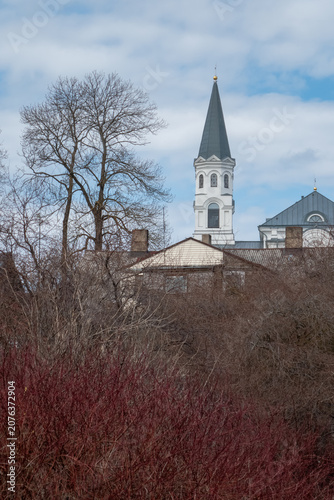 White church on a hill above village houses