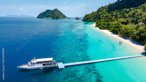 Fotografie Aerial drone view of tropical landscape over Madam Beach of Nyaung Oo Phee Island with tour boat anchoring on the floating dock in the Mergui Archipelago, Myanmar