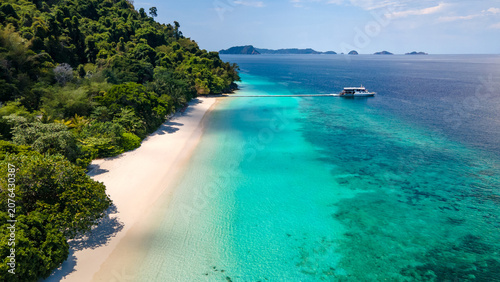 Fotografie Aerial drone view of tropical landscape over Madam Beach of Nyaung Oo Phee Island with tour boat anchoring on the floating dock in the Mergui Archipelago, Myanmar