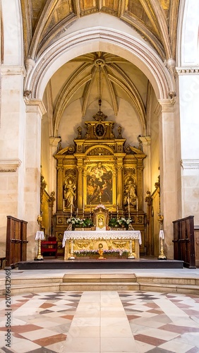 Grand gothic cathedral interior with ornate altar and pews.