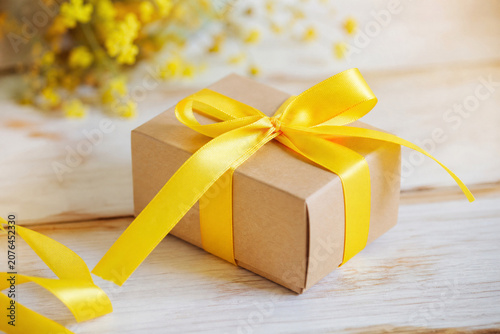 Laço amarelo em caixa de presente, simbolizando que a vida é um presente e a importância do apoio à saúde mental.