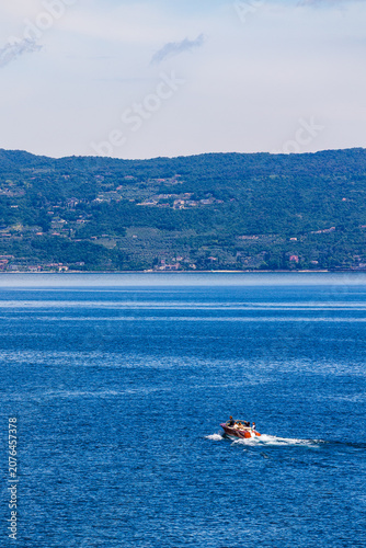 Fotografie Runabout boat speeding across the waters of Lake Garda